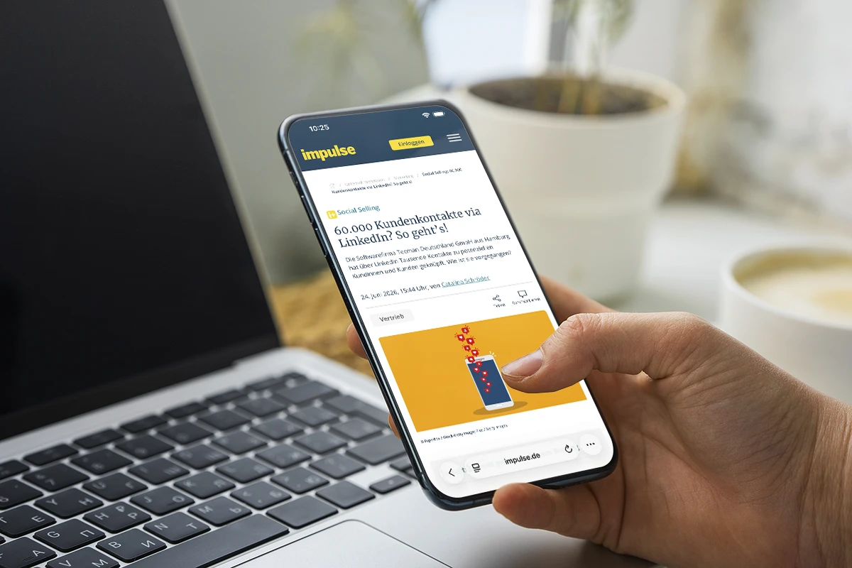 Smartphone mit impulse-Artikel über 60.000 Kundenkontakte via LinkedIn neben einem Laptop