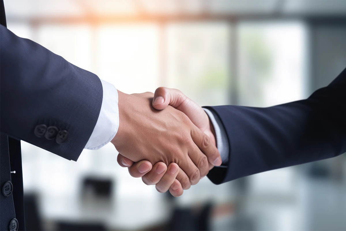 Zwei Geschäftspartner geben sich in einem modernen Büro die Hand – symbolisch für den Wechsel des Business Central Partners.